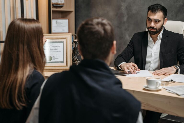 Ein Anwalt in einem eleganten Büro, der sich mit Mandanten trifft und Dokumente bespricht.